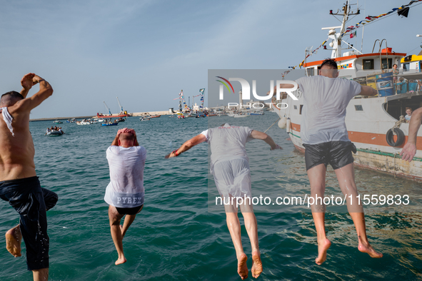 Sailors dive into the sea to greet the statue of Our Lady of Martyrs on the occasion of the patronal feast day in Molfetta, Italy, on Septem...