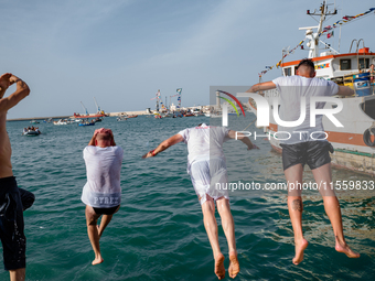 Sailors dive into the sea to greet the statue of Our Lady of Martyrs on the occasion of the patronal feast day in Molfetta, Italy, on Septem...