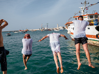 Sailors dive into the sea to greet the statue of Our Lady of Martyrs on the occasion of the patronal feast day in Molfetta, Italy, on Septem...