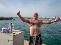 A sailor gets wet after diving into the sea to greet the statue of Our Lady of Martyrs on the occasion of the patronal feast day in Molfetta...