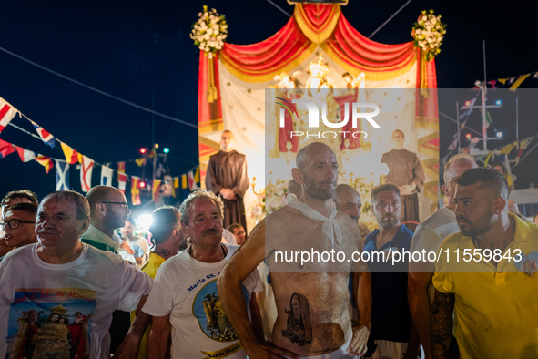 Sailors stand in front of the statue of Our Lady of Martyrs on the occasion of the patronal feast day in Molfetta, Italy, on September 8, 20...