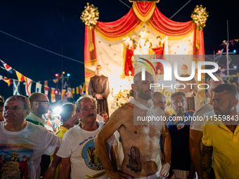 Sailors stand in front of the statue of Our Lady of Martyrs on the occasion of the patronal feast day in Molfetta, Italy, on September 8, 20...