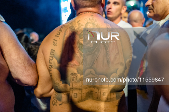 A sailor has a tattoo of the statue of Our Lady of Martyrs on his shoulder on the occasion of the patronal feast day in Molfetta, Italy, on...