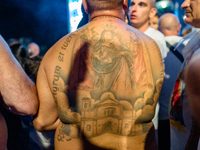 A sailor has a tattoo of the statue of Our Lady of Martyrs on his shoulder on the occasion of the patronal feast day in Molfetta, Italy, on...