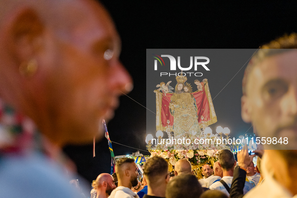 Sailors stand in front of the statue of Our Lady of Martyrs on the occasion of the patronal feast day in Molfetta, Italy, on September 8, 20...