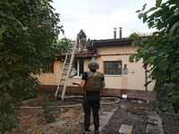 Police officers inspect the house for damage after Russian shelling with cluster munitions in Derhachi, Kharkiv region, north-eastern Ukrain...