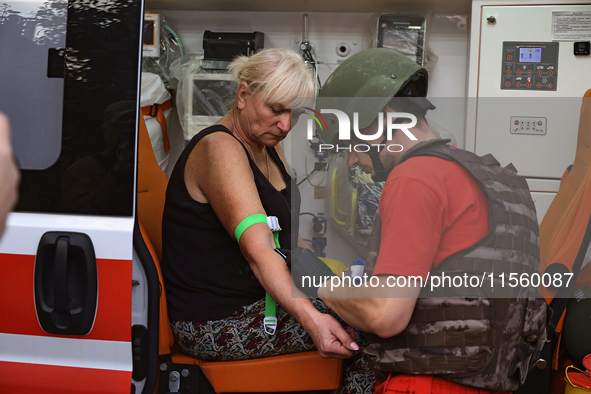 A medical worker provides aid to a woman injured as a result of Russian shelling with cluster munitions in Derhachi, Kharkiv region, north-e...