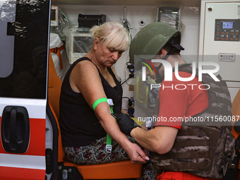 A medical worker provides aid to a woman injured as a result of Russian shelling with cluster munitions in Derhachi, Kharkiv region, north-e...