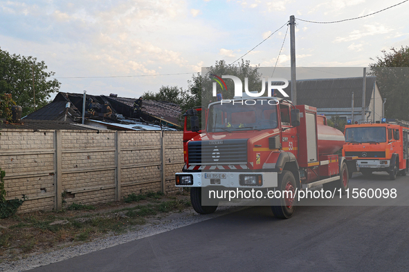 Fire trucks are seen outside the house damaged as a result of Russian shelling with cluster munitions in Derhachi, Kharkiv region, north-eas...