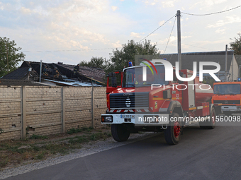 Fire trucks are seen outside the house damaged as a result of Russian shelling with cluster munitions in Derhachi, Kharkiv region, north-eas...