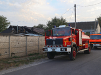 Fire trucks are seen outside the house damaged as a result of Russian shelling with cluster munitions in Derhachi, Kharkiv region, north-eas...