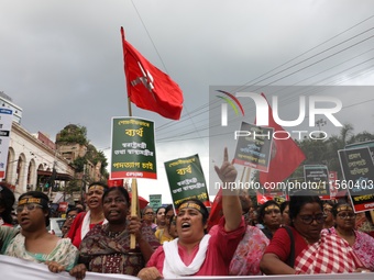 Activists shout slogans during heavy monsoon rain during a protest rally towards Kolkata Police Headquarters, Lalbazar, organized by the Com...