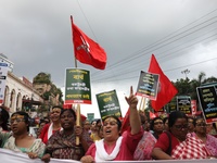 Activists shout slogans during heavy monsoon rain during a protest rally towards Kolkata Police Headquarters, Lalbazar, organized by the Com...