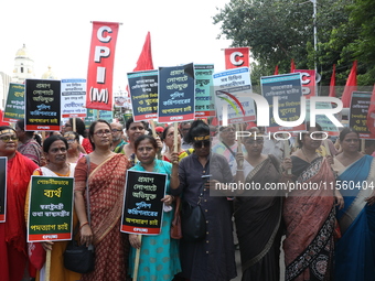 Activists shout slogans during heavy monsoon rain during a protest rally towards Kolkata Police Headquarters, Lalbazar, organized by the Com...