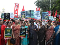 Activists shout slogans during heavy monsoon rain during a protest rally towards Kolkata Police Headquarters, Lalbazar, organized by the Com...