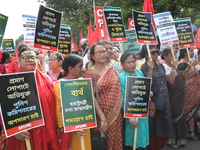 Activists shout slogans during heavy monsoon rain during a protest rally towards Kolkata Police Headquarters, Lalbazar, organized by the Com...