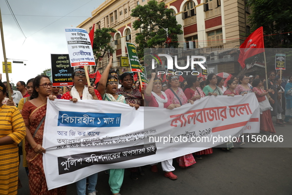 Activists shout slogans during heavy monsoon rain during a protest rally towards Kolkata Police Headquarters, Lalbazar, organized by the Com...