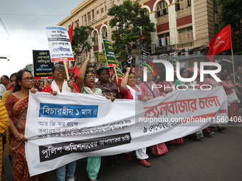 Activists shout slogans during heavy monsoon rain during a protest rally towards Kolkata Police Headquarters, Lalbazar, organized by the Com...