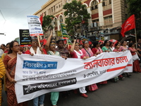 Activists shout slogans during heavy monsoon rain during a protest rally towards Kolkata Police Headquarters, Lalbazar, organized by the Com...