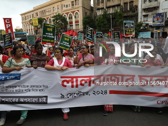 Activists shout slogans during heavy monsoon rain during a protest rally towards Kolkata Police Headquarters, Lalbazar, organized by the Com...