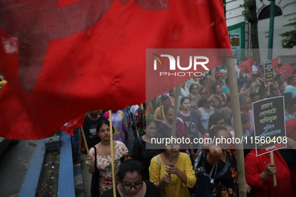 Activists shout slogans during heavy monsoon rain during a protest rally towards Kolkata Police Headquarters, Lalbazar, organized by the Com...