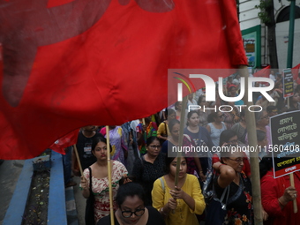 Activists shout slogans during heavy monsoon rain during a protest rally towards Kolkata Police Headquarters, Lalbazar, organized by the Com...