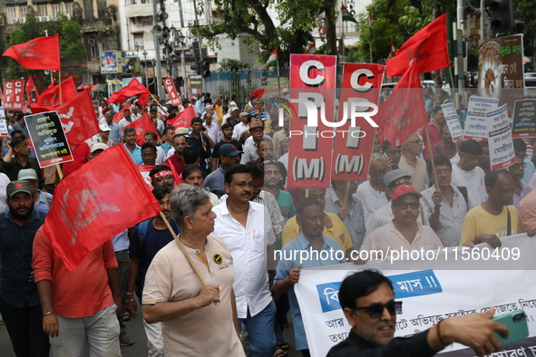 Activists shout slogans during heavy monsoon rain during a protest rally towards Kolkata Police Headquarters, Lalbazar, organized by the Com...