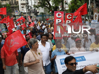 Activists shout slogans during heavy monsoon rain during a protest rally towards Kolkata Police Headquarters, Lalbazar, organized by the Com...