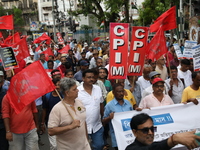 Activists shout slogans during heavy monsoon rain during a protest rally towards Kolkata Police Headquarters, Lalbazar, organized by the Com...