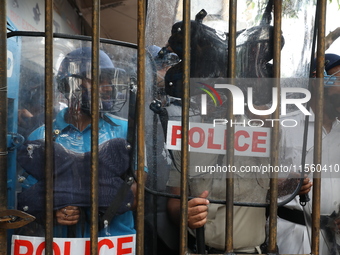 Activists shout slogans during heavy monsoon rain during a protest rally towards Kolkata Police Headquarters, Lalbazar, organized by the Com...