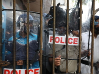 Activists shout slogans during heavy monsoon rain during a protest rally towards Kolkata Police Headquarters, Lalbazar, organized by the Com...