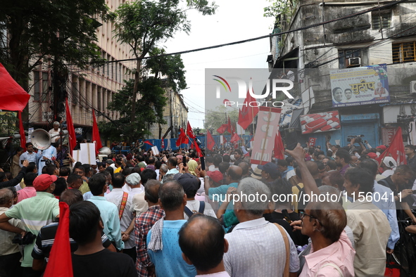 Activists shout slogans during heavy monsoon rain during a protest rally towards Kolkata Police Headquarters, Lalbazar, organized by the Com...