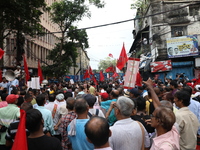 Activists shout slogans during heavy monsoon rain during a protest rally towards Kolkata Police Headquarters, Lalbazar, organized by the Com...