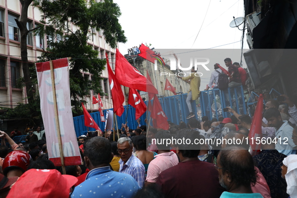 Activists shout slogans during heavy monsoon rain during a protest rally towards Kolkata Police Headquarters, Lalbazar, organized by the Com...