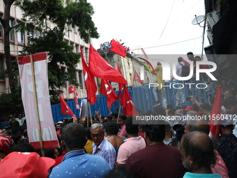 Activists shout slogans during heavy monsoon rain during a protest rally towards Kolkata Police Headquarters, Lalbazar, organized by the Com...