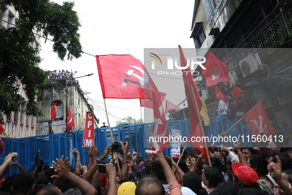 Activists shout slogans during heavy monsoon rain during a protest rally towards Kolkata Police Headquarters, Lalbazar, organized by the Com...