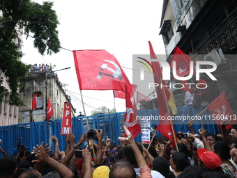 Activists shout slogans during heavy monsoon rain during a protest rally towards Kolkata Police Headquarters, Lalbazar, organized by the Com...