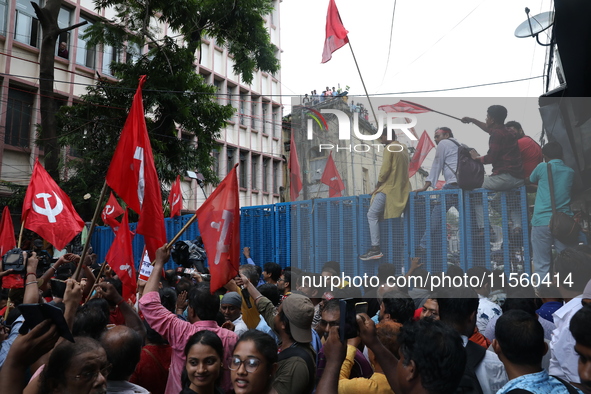 Activists shout slogans during heavy monsoon rain during a protest rally towards Kolkata Police Headquarters, Lalbazar, organized by the Com...