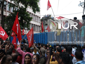 Activists shout slogans during heavy monsoon rain during a protest rally towards Kolkata Police Headquarters, Lalbazar, organized by the Com...