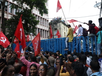 Activists shout slogans during heavy monsoon rain during a protest rally towards Kolkata Police Headquarters, Lalbazar, organized by the Com...