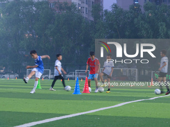 Children practice soccer at the evening soccer field of Capital Sport University in Beijing, China, on September 9, 2024. (