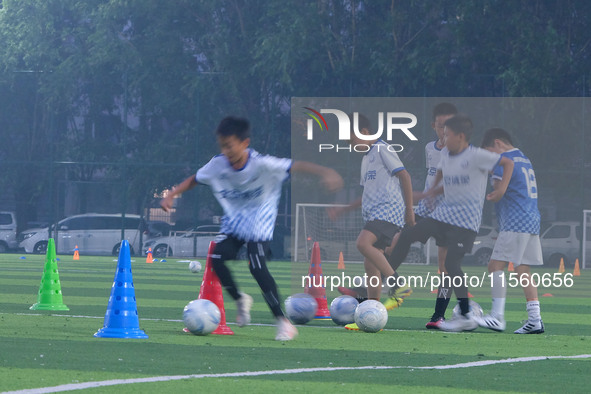 Children practice soccer at the evening soccer field of Capital Sport University in Beijing, China, on September 9, 2024. 