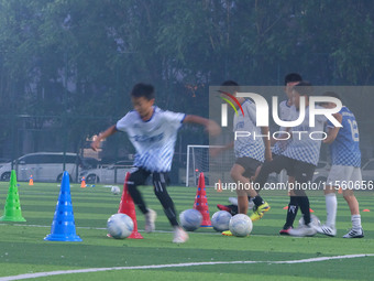 Children practice soccer at the evening soccer field of Capital Sport University in Beijing, China, on September 9, 2024. (