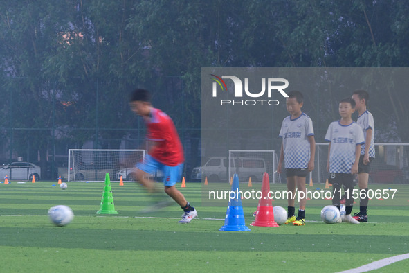 Children practice soccer at the evening soccer field of Capital Sport University in Beijing, China, on September 9, 2024. 