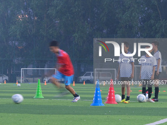 Children practice soccer at the evening soccer field of Capital Sport University in Beijing, China, on September 9, 2024. (