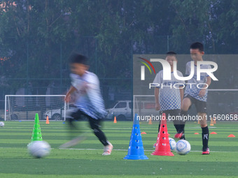 Children practice soccer at the evening soccer field of Capital Sport University in Beijing, China, on September 9, 2024. (