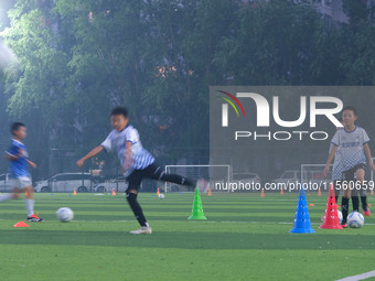 Children practice soccer at the evening soccer field of Capital Sport University in Beijing, China, on September 9, 2024. (