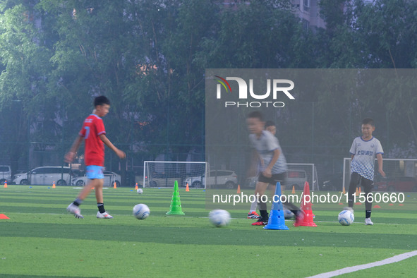 Children practice soccer at the evening soccer field of Capital Sport University in Beijing, China, on September 9, 2024. 