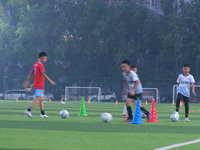 Children practice soccer at the evening soccer field of Capital Sport University in Beijing, China, on September 9, 2024. (