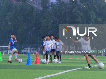 Children practice soccer at the evening soccer field of Capital Sport University in Beijing, China, on September 9, 2024. (